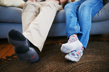 Image showing Legs, feet in socks and a couple on a sofa in the living room of their home together closeup to relax. Love, relationship and bonding with people in their house for a break on weekend in winter