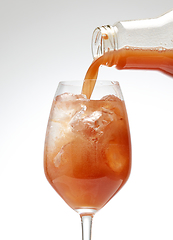 Image showing fresh juice pouring into cocktail glass 