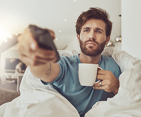 Image showing Frustrated, watching tv and man on sofa with tea to relax with a show for fatigue. Tired, sad and a person with a remote for a film, coffee and on the home couch for television, news or subscription