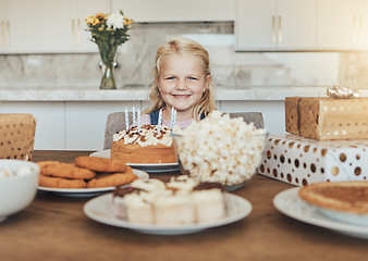 Image showing Child, birthday cake and celebration with gifts, home or smile for food, desserts or happy. Portrait, party or kitchen for girl, candles or face for special, excited and giving to eat, enjoy or snack