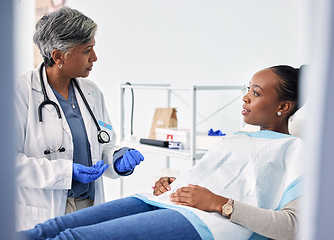 Image showing Dental, consultation and dentist with woman in a clinic for oral health or teeth examination. Checkup, discussion and senior female medical worker talking to African patient in a medicare hospital.