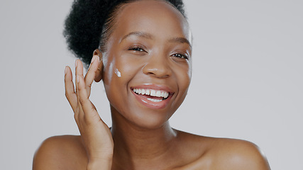 Image showing Portrait, cream and face of black woman in studio for beauty, dermatology and aesthetic makeup on grey background. Happy model, sunscreen lotion and facial cosmetics for clean skincare, glow or shine