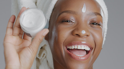 Image showing Woman, moisturizer and smile in portrait for skincare or beauty, health and wellness or dermatology. Happy black person, skin and cosmetics, care and cream on face in studio by gray background