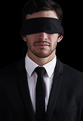 Image showing Dark, vision and a business man in a blindfold on a black background for control or censorship. Oppression, lost and blinded with a young corporate employee unaware of future issues as a professional