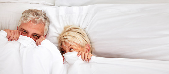 Image showing Senior couple, hiding and smile in bed for fun, comfort and bonding for love, silly and goofy together. Elderly people, marriage and sex in bedroom in retirement, romance and happiness at home