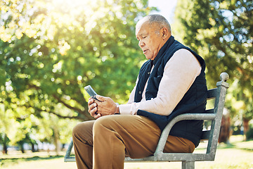 Image showing Senior man, garden and browsing on phone for social media, learning and network with internet or technology on park bench, nature and outdoors. Elderly person, email and chat on smartphone or mobile