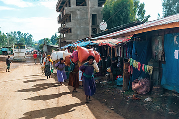 Image showing Ethiopian women carry heavy loads on their backs in sacks, Ethiopia