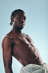 Image showing Body, black man and portrait in studio with art, skincare and glow from skin wellness and fitness confidence. Strong muscle and African male model with creative blue background and relax with power