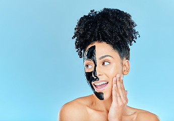 Image showing Mockup, charcoal mask and face of happy woman for facial treatment, anti aging and wellness in studio. Beauty, salon and person for healthy skin, cosmetics and grooming on blue background space