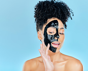 Image showing Skincare, charcoal mask and woman in studio for facial treatment, anti aging detox and wellness. Beauty, salon and face of person with product for health, cosmetics or grooming on blue background