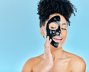 Image showing Skincare, face mask and woman in studio for charcoal facial treatment, anti aging and wellness. Beauty salon, dermatology and face of person for health, cosmetics or grooming on blue background