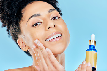 Image showing Beauty serum, portrait and woman with bottle, container and apply collagen, essential oil or retinol for skin hydration. Cosmetics face product, facial skincare and studio person on blue background