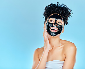 Image showing Skincare, happy and woman with charcoal face mask for facial treatment, anti aging and wellness in studio. Beauty, dermatology and happy person for health, cosmetics or grooming on blue background