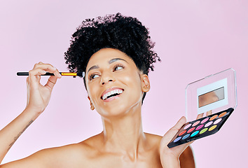 Image showing Face makeup, palette and happy woman with brush, beauty routine and apply cosmetics powder, foundation or product. Happiness, skincare shine and studio person with skin treatment on pink background