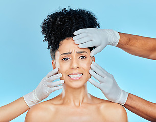 Image showing Plastic surgery, portrait of scared woman with hands on face in studio for skincare consultation. Model with stress, fear and anxiety for beauty, dermatology or collagen therapy on blue background.