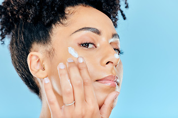 Image showing Beauty, studio portrait and woman with cream application of ointment, lotion or creme for skin hydration, wellness or skincare. Melasma treatment, face acne protection and model on blue background