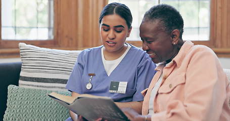 Image showing Elderly, woman or nurse with book for reading, relax or retirement on sofa in living room of nursing home. Senior, professional or caregiver with novel, communication or discussion on couch in lounge