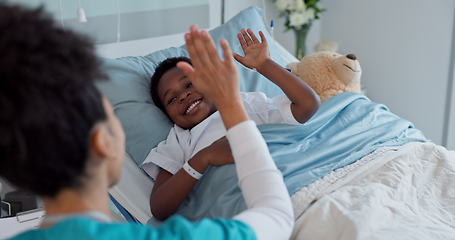 Image showing Happy woman, doctor and high five with kid patient for success, teamwork or good job on hospital bed. Friendly female person or medical nurse touching hands of little boy for child support at clinic