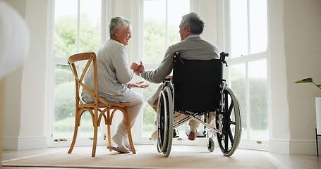 Image showing Wheelchair, senior couple and conversation in a retirement and nursing home with support and holding hands. Back, love and man with a disability with speaking and discussion with empathy in marriage