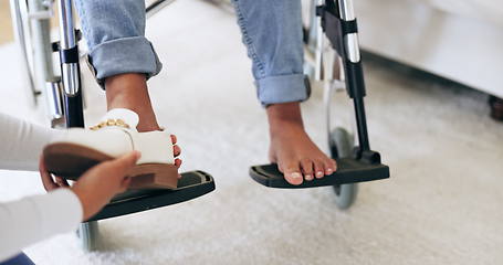 Image showing Caregiver, help and shoes of patient in wheelchair, healthcare and assistance in nursing home. Nurse, closeup of hands and take off footwear of person with a disability for support of medical worker