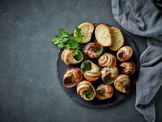 Image showing plate of baked escargot snails filled with parsley and garlic bu