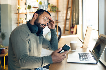 Image showing Man, phone and stress in coffee shop for remote work, job search or bad news of financial fail, debt or loan. African freelancer with headache, worry or reading on mobile, business decision and cafe