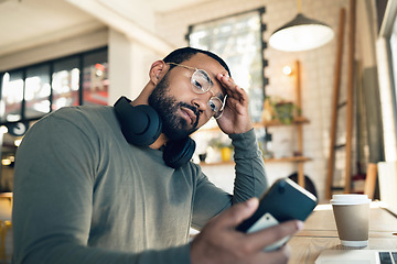 Image showing Man, phone and headache in coffee shop for remote work, job search or bad news of financial fail, debt or loan. African person with stress, worry or confused reading information on his mobile at cafe