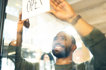 Image showing Happy man, small business and open sign on door or window in ready for service or welcome at cafe. Male person, barista or waiter smile with entrance at coffee shop, restaurant or cafeteria store