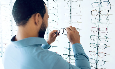 Image showing Optometry, vision and man with glasses for decision, choice and eye care option in optician store. Healthcare, ophthalmology and person in clinic to choose prescription lens, spectacles and frames