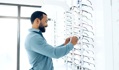 Image showing Optometry store glasses and man for decision, choice and eye care options for vision. Healthcare, ophthalmology and person in clinic to choose prescription lens, spectacles and frames for wellness