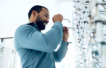 Image showing Optometry, vision and happy man with glasses for decision, choice and eye care option in optician store. Healthcare, ophthalmology and person in clinic for prescription lens, spectacles and frames