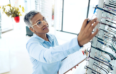 Image showing Stock, optometrist or mature woman with glasses checklist in store for retail inventory or eyewear choice. Vision, product or optician in clinic writing on clipboard for eye care in optometry shop