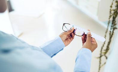 Image showing Hands, measuring lens and frame of glasses, person in optometry clinic with eye care, test and healthcare. Eyewear, wellness and prescription with health, spectacles and optometrist with ruler tools