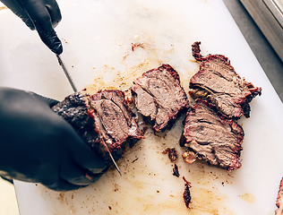 Image showing Chef hands cut grill steak at kitchen restaurant.
