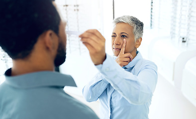 Image showing Vision, eyes and medical test with a man at the optometrist for prescription diagnosis or assessment. Distance, measure or exam with a customer talking to a consultant at the optician for assistanc