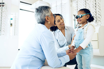 Image showing Optometrist, mother and child holding hands shopping for spectacles in trial frame at store. Mature ophthalmologist, mom and happy kid in test for glasses, vision and consulting for health or support