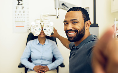 Image showing Man, eye exam and phoropter with optometrist, portrait and check with lens, vision and wellness in clinic. Doctor, eyesight tools and machine for assessment, consultation and healthcare in hospital