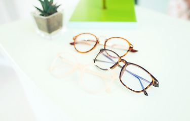 Image showing Glasses, vision and choice, optometry and frame with prescription lens on table, display and eye care. Designer, fashion and eyewear, health and product closeup, service and ophthalmology background