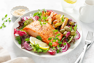 Image showing Salmon fillet grilled, fried potato and fresh vegetable green salad