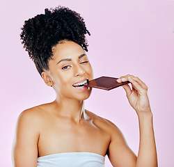 Image showing Portrait, sweet diet and woman with chocolate, eating and diabetes on a pink studio background. Face, person and model with unhealthy food, cacao treat and calories with sugar, nutrition and snack