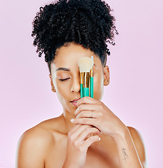 Image showing African, woman and brush for makeup on face fro beauty, cosmetic tools or pink background in studio. Cosmetics, artist and person with creative skincare brushes for foundation or powder application