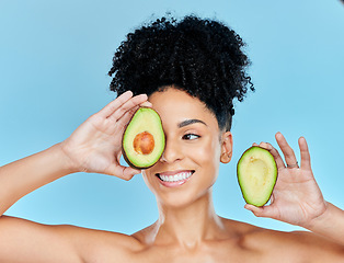 Image showing Avocado, skincare and beauty, woman with natural benefits and product for face on blue background. Health, wellness and facial mask, smile with green fruit and vegan for dermatology in studio