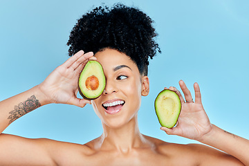 Image showing Happy woman, face and avocado for natural skincare, beauty or diet against a blue studio background. Female person or model smile with organic vegetable for nutrition, vitamin C or skin wellness