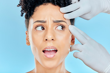 Image showing Beauty, plastic surgery and scared woman with hands on face in studio for cosmetic facial consultation. Skincare, dermatology and professional collagen therapy, model on blue background with fear.