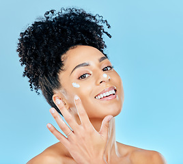 Image showing Beauty, studio portrait and happy woman with cream application, ointment product or lotion for skin hydration glow. Skincare treatment, protection and aesthetic model happiness on blue background