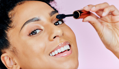 Image showing Closeup, happy woman and mascara for makeup in studio with lashes or cosmetics on pink background. African, female model and smile in portrait for beauty, treatment and confidence with application