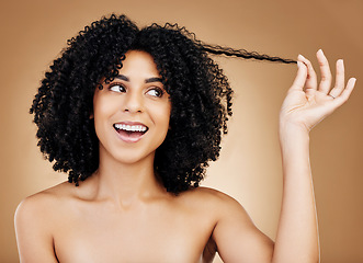 Image showing Curly hair, strand and woman in studio for beauty, healthy growth or natural coil textures on brown background. Happy model pull afro hairstyle for salon aesthetic, keratin treatment or cosmetic care