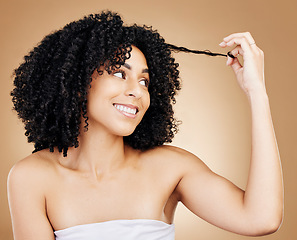 Image showing Afro, happy woman and beauty of hair strand in studio for natural growth, coil textures or results on brown background. Model, curly hairstyle or care of salon aesthetic, keratin treatment or shampoo