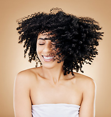 Image showing Woman, shake hair with curls and shine, smile for salon treatment or natural beauty with strong texture on studio background. Wind, energy and growth, haircare and cosmetology with happy model