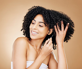 Image showing Afro, hair and comb of woman in studio with healthy coil texture, natural growth or cosmetics on brown background. Happy model, curly haircare tools or brush for salon aesthetic, care or clean beauty